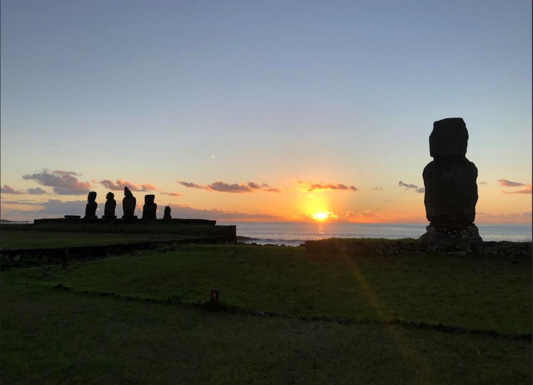 Fotografía referencial de un atardecer en Rapa Nui con moái de fondo