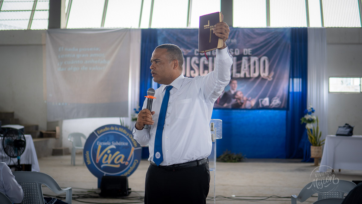 El pastor Libardo Vaca se dirige a los asistentes al encuentro en El Bagre mientras sostiene una Biblia.