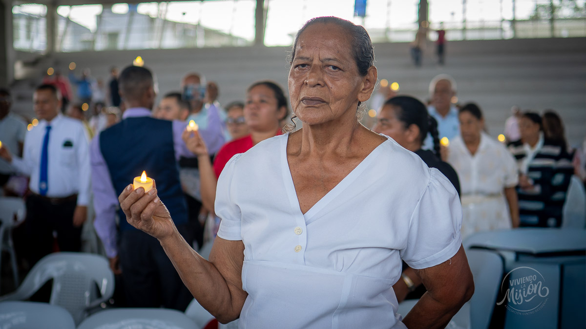 Asistente sostiene una luz encendida durante el acto simbólico al cierre del encuentro en El Bagre.