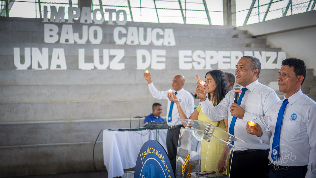 Asistente sostiene una luz encendida durante el acto simbólico al cierre del encuentro en El Bagre.