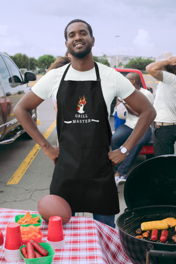 Man grilling meat at a football tailgate