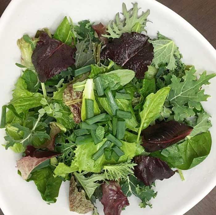 A great way to add flavor to any salad or dish is with a garnish of freshly-harvested green onions. You can see a generous topping of diced scallions applied to this wintertime mixed green salad.