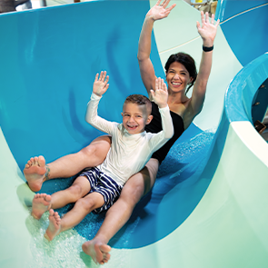 Mother and son going down a water slide