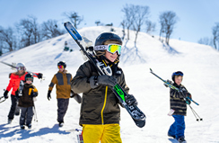 Young boy walking with his skis