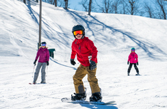Boy snowboarding down the ski hill