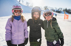 Three girls smiling at the ski hill