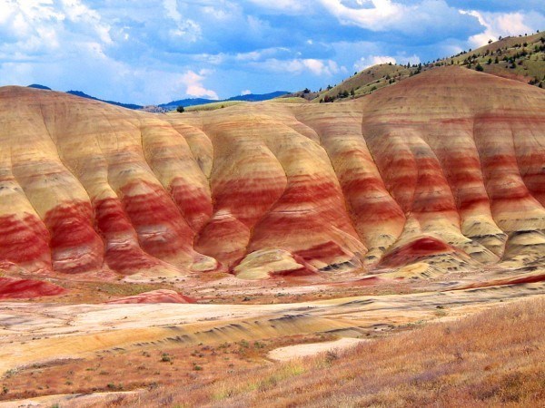 DISTINGUISHED BY VARIED STRIPES OF RED, TAN, ORANGE, AND BLACK, THIS AREA PRESERVES A SEQUENCE OF PAST CLIMATE CHANGE. Painted Hills at John Day Fossil Beds