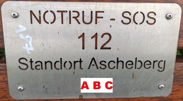 Notruf - SOS - Schild an Bank - Standortnummer mit ABC überschrieben