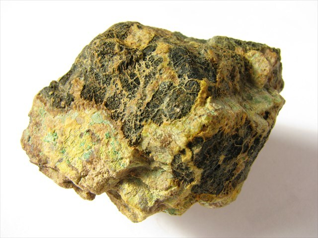 Smolinec - uránová ruda, pokrytý žltými povlakmi sekundárnych minerálov uránu.