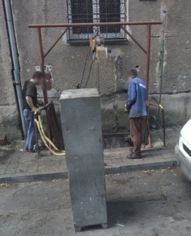 dělníci používají otevřenou šachtu k úklidu