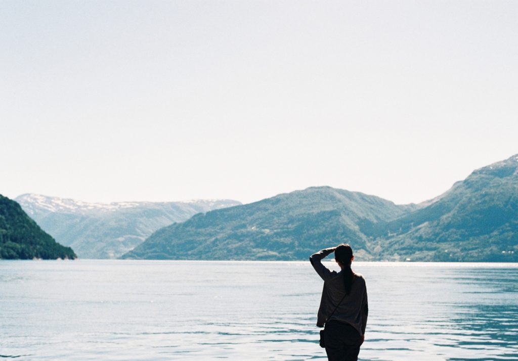 Woman at peace by a lake in the mountains