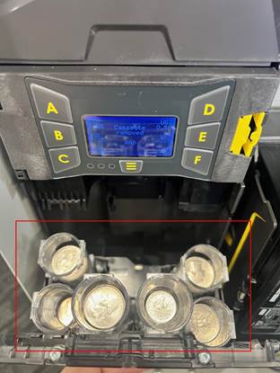 A machine with several small plastic cupsAI-generated content may be incorrect.