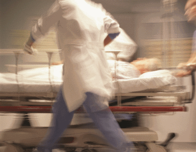 IR in ER doctors rushing down hall with patient on bed