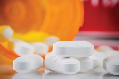 Opioid image Tablets spilling out of bottle