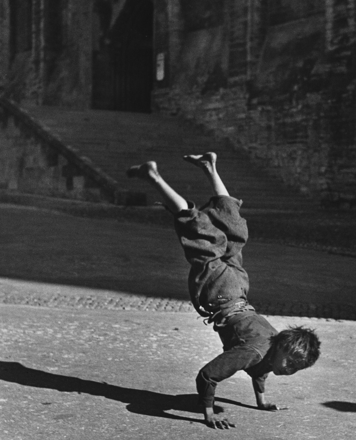 Garçon équilibrant sur ses mains, (Boy balancing on his hands)