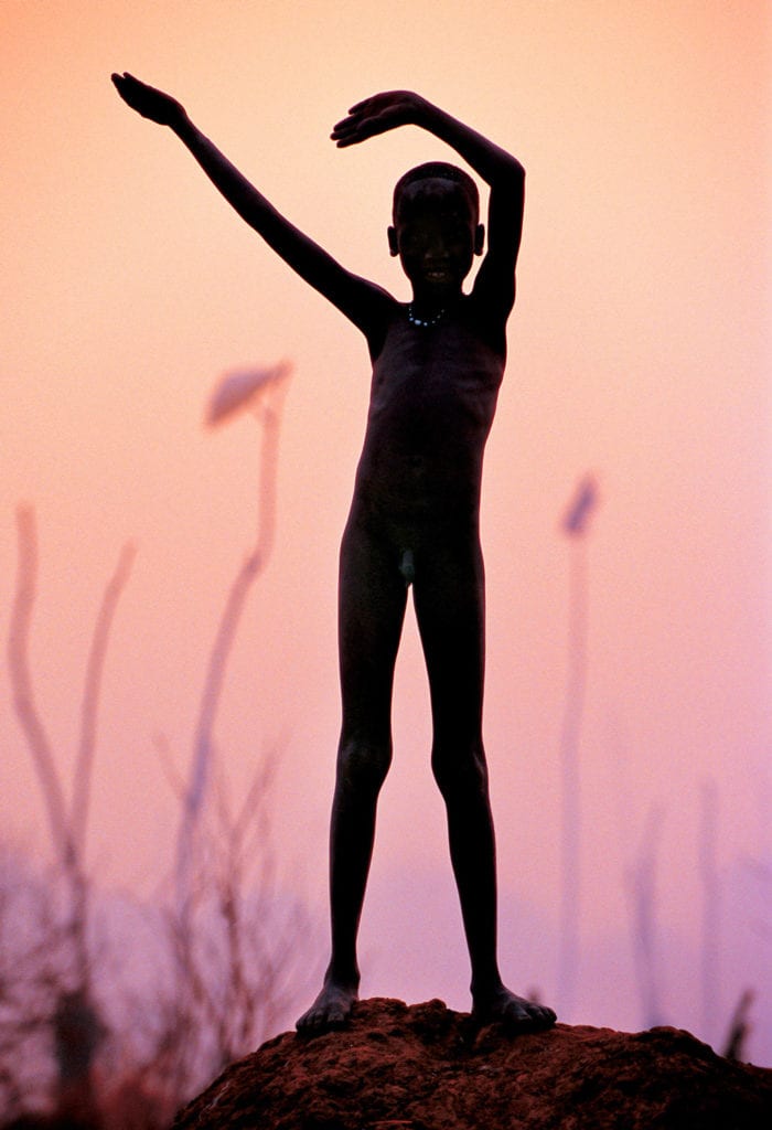 Carol Beckwith & Angela Fisher, Dinka Child Imitating Horns of a Favorite Bull, South Sudan