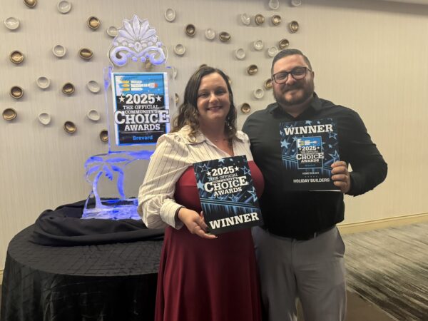 Two people holding an award.