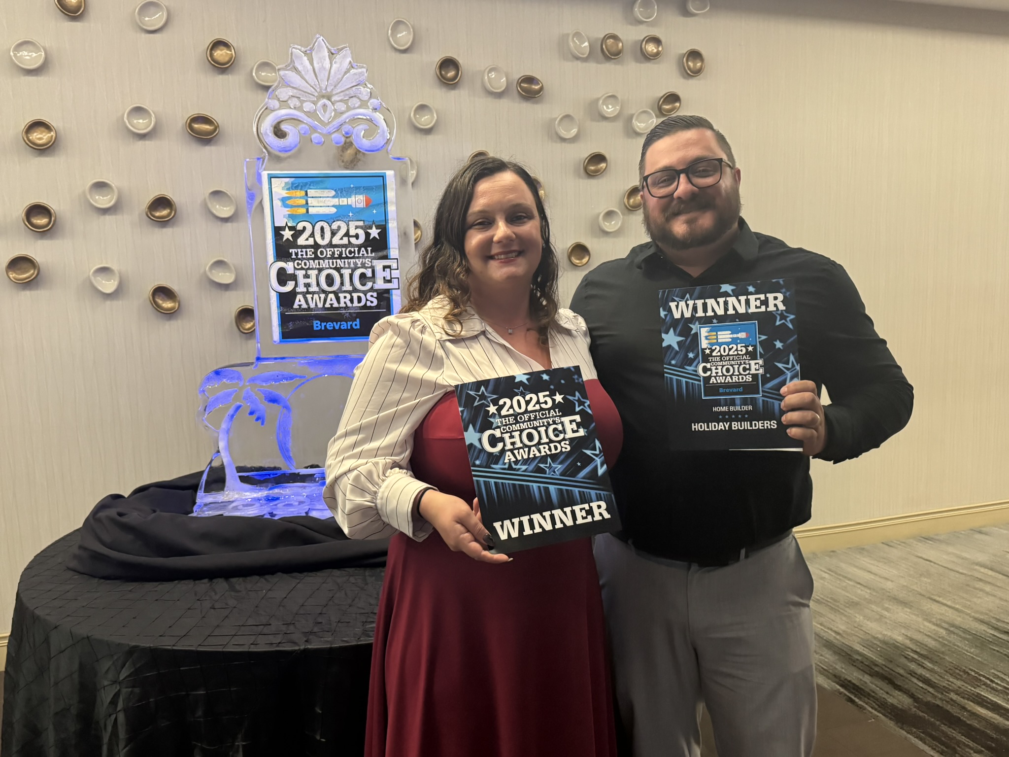 Two people holding an award.