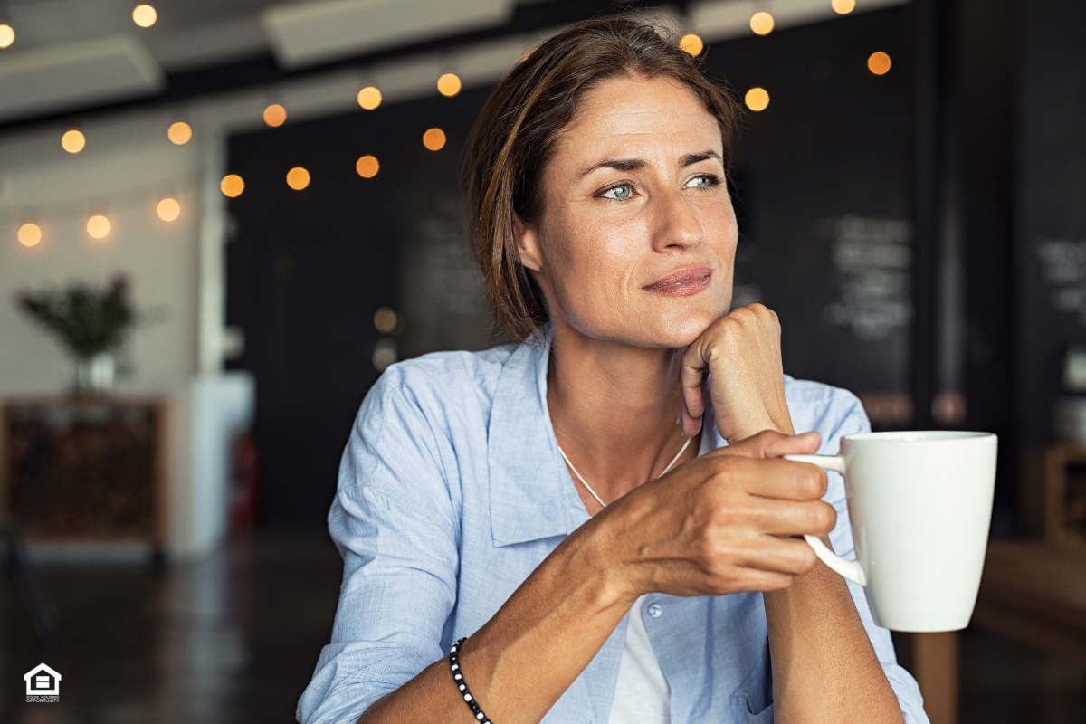 Woman with coffee, thinking about mortgage rates.