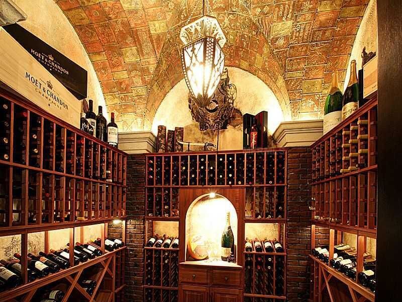 CLWCTT Small wine cellar with intricately designed ceiling. Cabinets include display storage sections for featuring select wines.