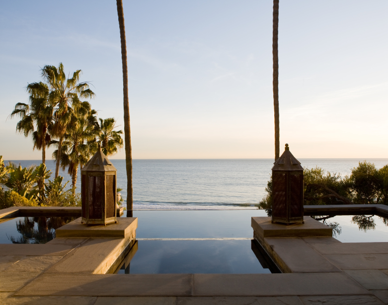 The limestone patio leads directly into the pool, which gets deeper once past the two posts lit by antique lanterns. Just beyond the edge of the pool is the beach, close enough to hear the waves roll in. The limestone patio leads directly into the pool, which gets deeper once past the two posts lit by antique lanterns. Just beyond the edge of the pool is the beach, close enough to hear the waves roll in.