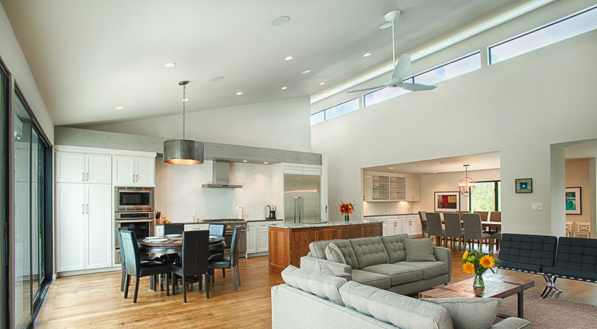 This wide view of the central space showcases the vast expanse of open air, connecting the disparate ends of the home. Rich wood, white walls, and muted grey and black tones keep the area grounded. This wide view of the central space showcases the vast expanse of open air, connecting the disparate ends of the home. Rich wood, white walls, and muted grey and black tones keep the area grounded.