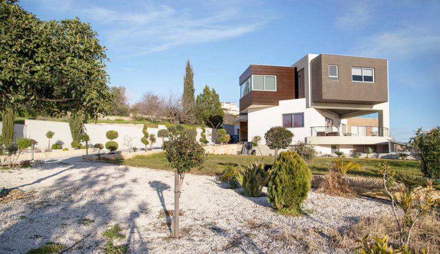 An intricate and water-efficient garden wraps the home, in full view of the myriad large windows and upper level patio. The modern, angular forms stand out on the structure. An intricate and water-efficient garden wraps the home, in full view of the myriad large windows and upper level patio. The modern, angular forms stand out on the structure.