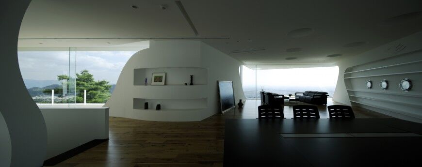 Although these walls are all the same pristine white, shelving and curved elements on one wall distinguish it from the others.