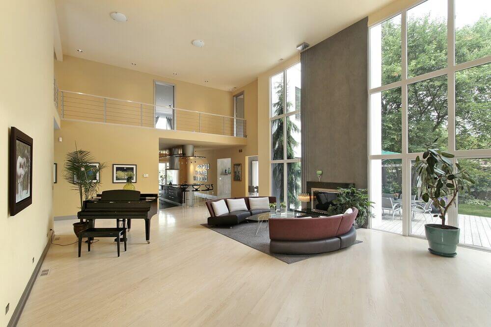 This cavernous living room is incredibly open and minimalist in its design. A single two-story accent wall to the right of the seating area provides a depth of color and contrast to the pale yellow walls.