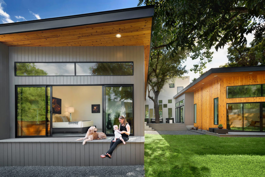 Seen from the back, the pair of single floor wings reach outward from the two story hub, hugging a cozy courtyard space. The bedrooms and other spaces all feature expansive windows, affording expansive landscape views. Seen from the back, the pair of single floor wings reach outward from the two story hub, hugging a cozy courtyard space. The bedrooms and other spaces all feature expansive windows, affording expansive landscape views.