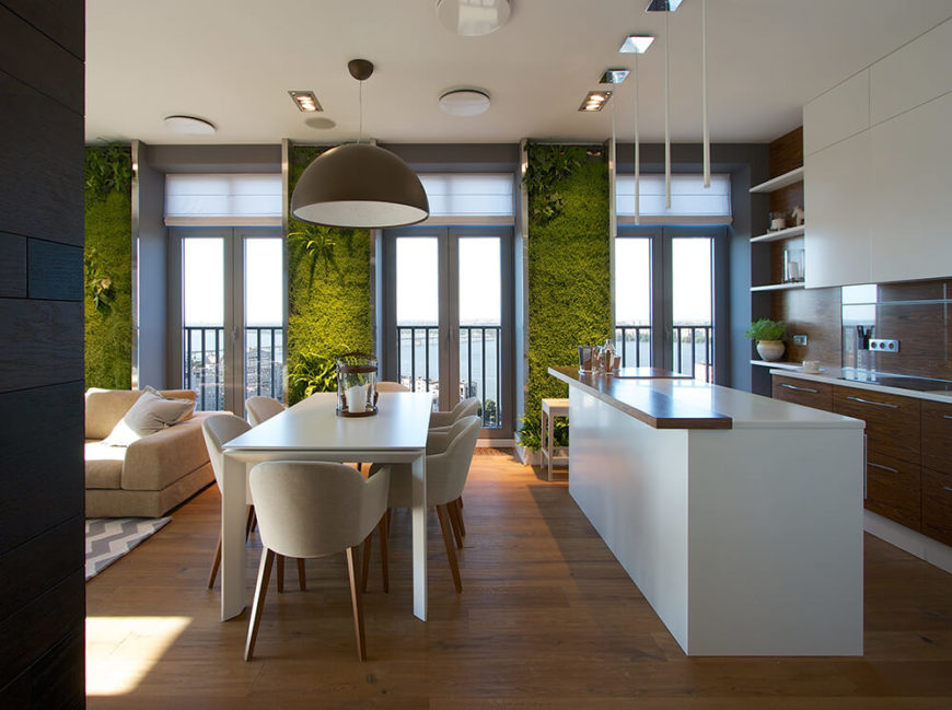 From this angle, we can see the entirety of the dining room, which sits squarely between the living room and the lovely kitchen. The kitchen is in sleek minimalistic white and rich, warm-toned wood. From this angle, we can see the entirety of the dining room, which sits squarely between the living room and the lovely kitchen. The kitchen is in sleek minimalistic white and rich, warm-toned wood.