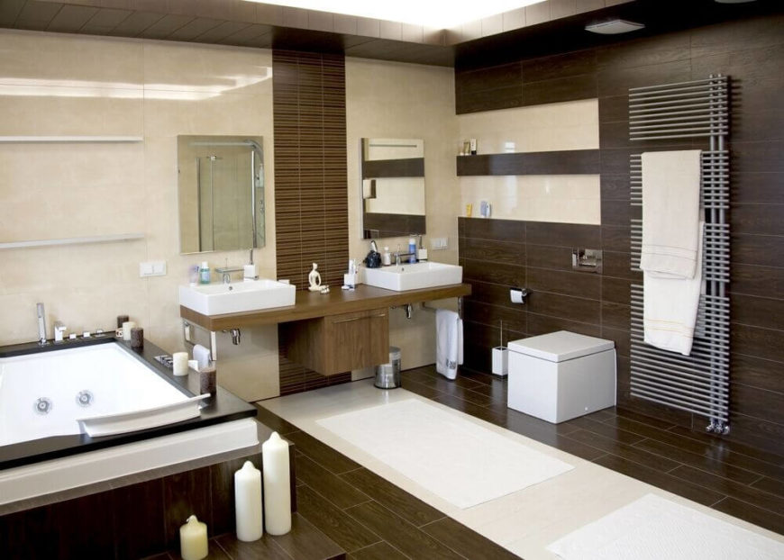 Dark wood is abundant in this modern bathroom. A large jacuzzi tub in the left corner is the focal point of the room. Dual vessel sinks share the same vanity, but the mirrors above each are visually separated by a floor-to-ceiling tile panel. The stainless steel towel rack ensures plenty of storage for towels. Dark wood is abundant in this modern bathroom. A large jacuzzi tub in the left corner is the focal point of the room. Dual vessel sinks share the same vanity, but the mirrors above each are visually separated by a floor-to-ceiling tile panel. The stainless steel towel rack ensures plenty of storage for towels.