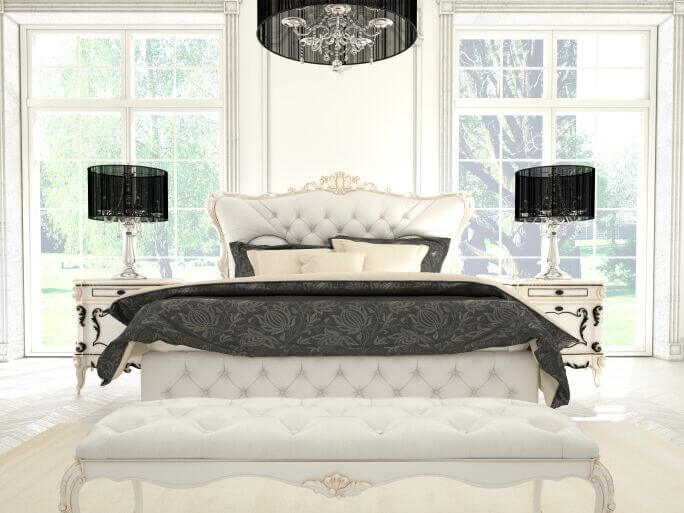 This monochromatic bedroom features elegant detailing on the furniture, bold patterning on the bed linens, and a striking chandelier over the large bed. This monochromatic bedroom features elegant detailing on the furniture, bold patterning on the bed linens, and a striking chandelier over the large bed.