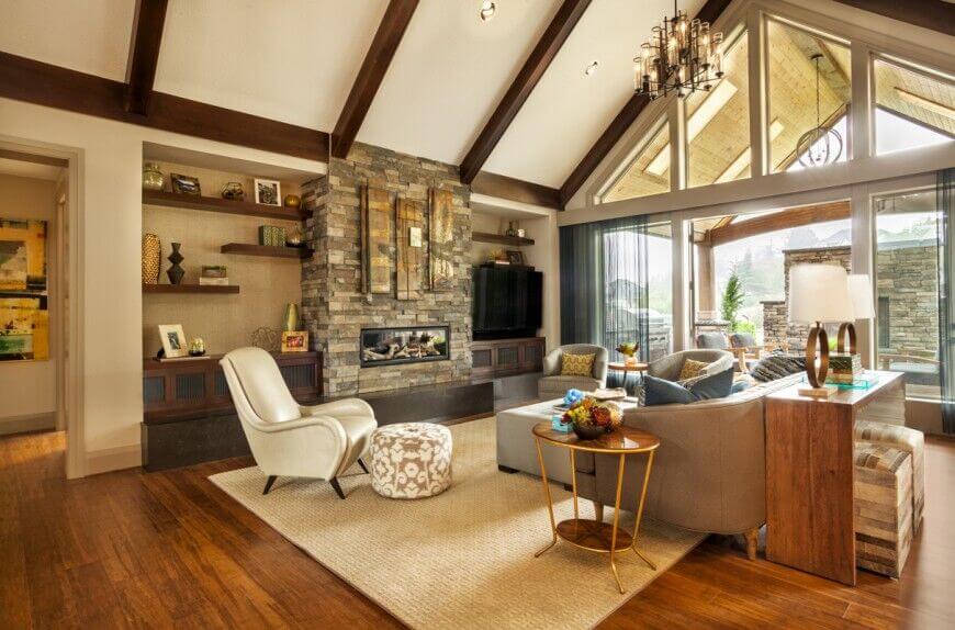 Here's another great vaulted ceiling in white, with dark wood exposed beams for contrast. The rich furnishings of the living room stand in natural light, courtesy of full height windows.