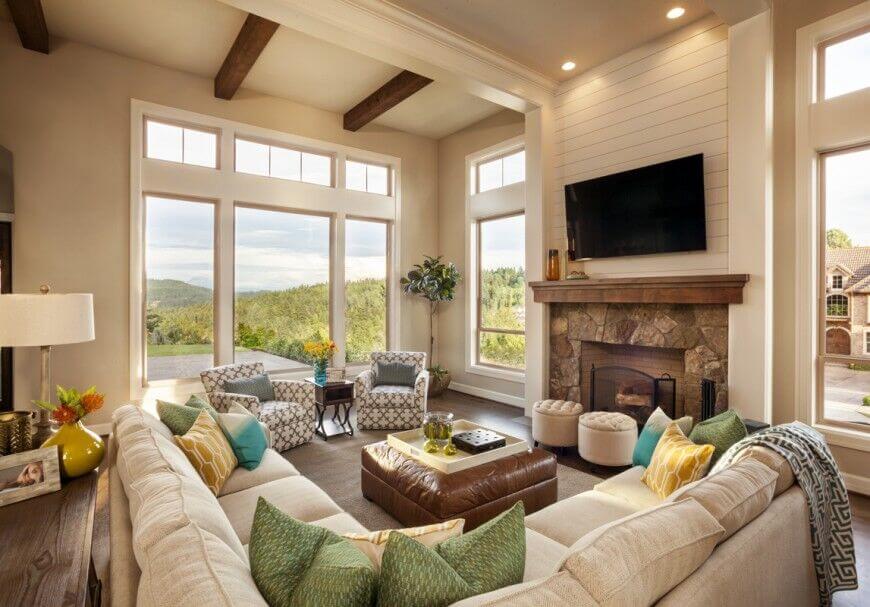 In a contemporary setting wrapped in off-white and grounded by rich hardwood flooring, the double height ceiling adds some fine contrast with dark exposed wood beams. Tall windows allow for an open, airy look.