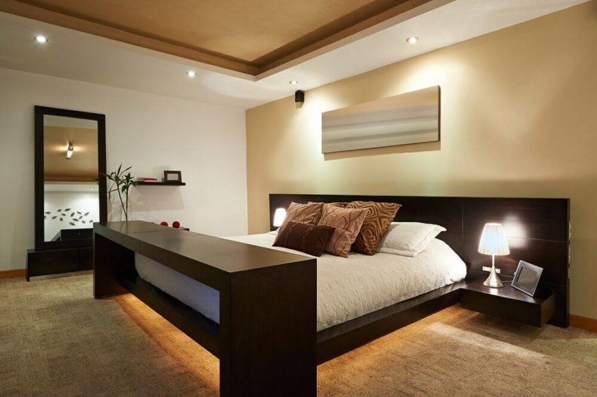 The unique lighting in this room creates a calm atmosphere, while the bed sits centered in the space. The color of the vaulted ceiling is complemented by the accent wall and the carpet. The unique lighting in this room creates a calm atmosphere, while the bed sits centered in the space. The color of the vaulted ceiling is complemented by the accent wall and the carpet.