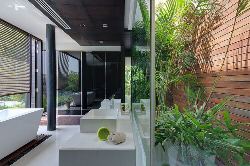 The mater bath is a striking modern space, mixing glass, white marble, rich natural wood, and rows of bright greenery. A pedestal tub at left can be enjoyed with wraparound views of nature. The mater bath is a striking modern space, mixing glass, white marble, rich natural wood, and rows of bright greenery. A pedestal tub at left can be enjoyed with wraparound views of nature.