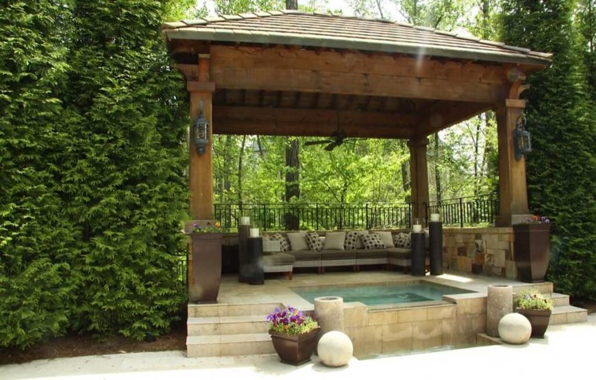 This fabulous gazebo houses not only a lovely stone hot tub but a set 