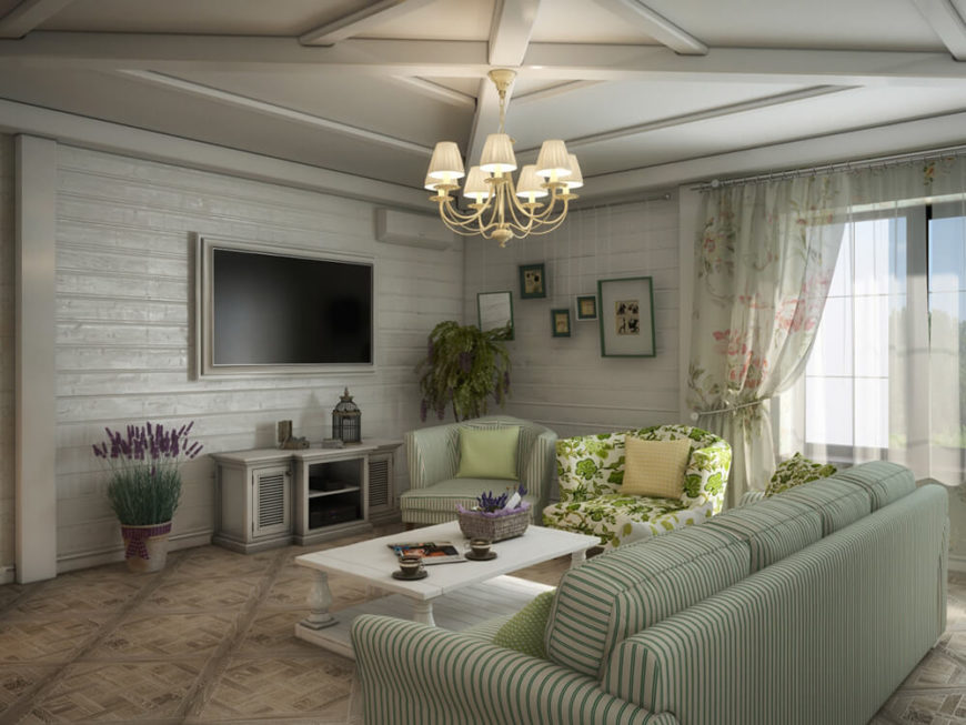 The living room sits beneath a lightly vaulted ceiling with intricately detailed wood beams. The corner is anchored by a white painted wooden feature wall. The living room sits beneath a lightly vaulted ceiling with intricately detailed wood beams. The corner is anchored by a white painted wooden feature wall.