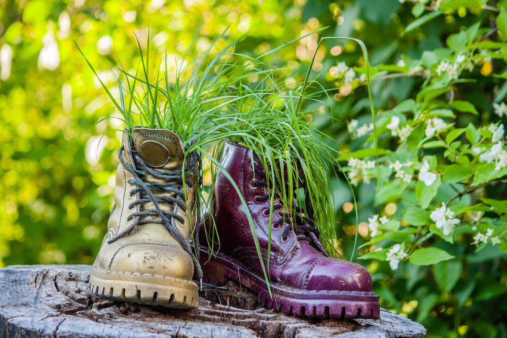 If you want to create a more artistic piece, choose a couple of discarded boots that you can use as planters, spray them with funky shiny colors, and then display them on a cut-up tree trunk.