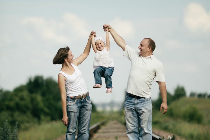 parents with baby on railroad