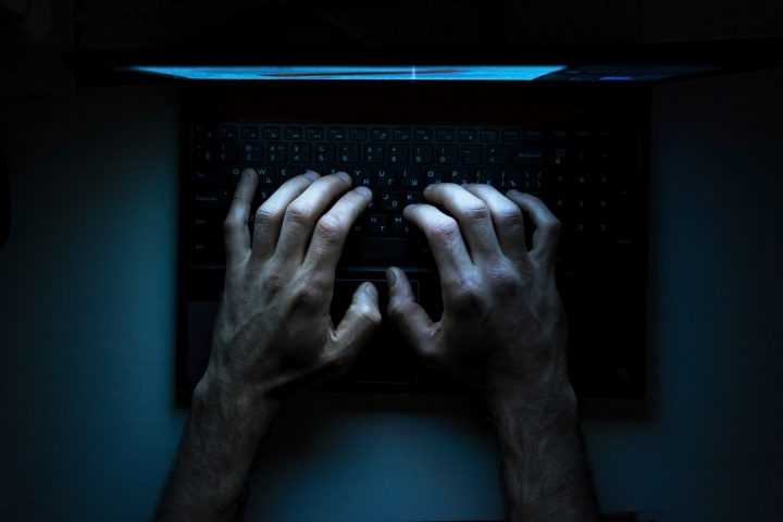 Top view of the hands of a programmer on his laptop