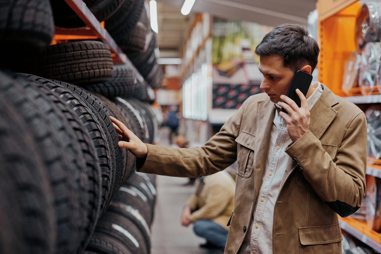 man on phone looking at tires