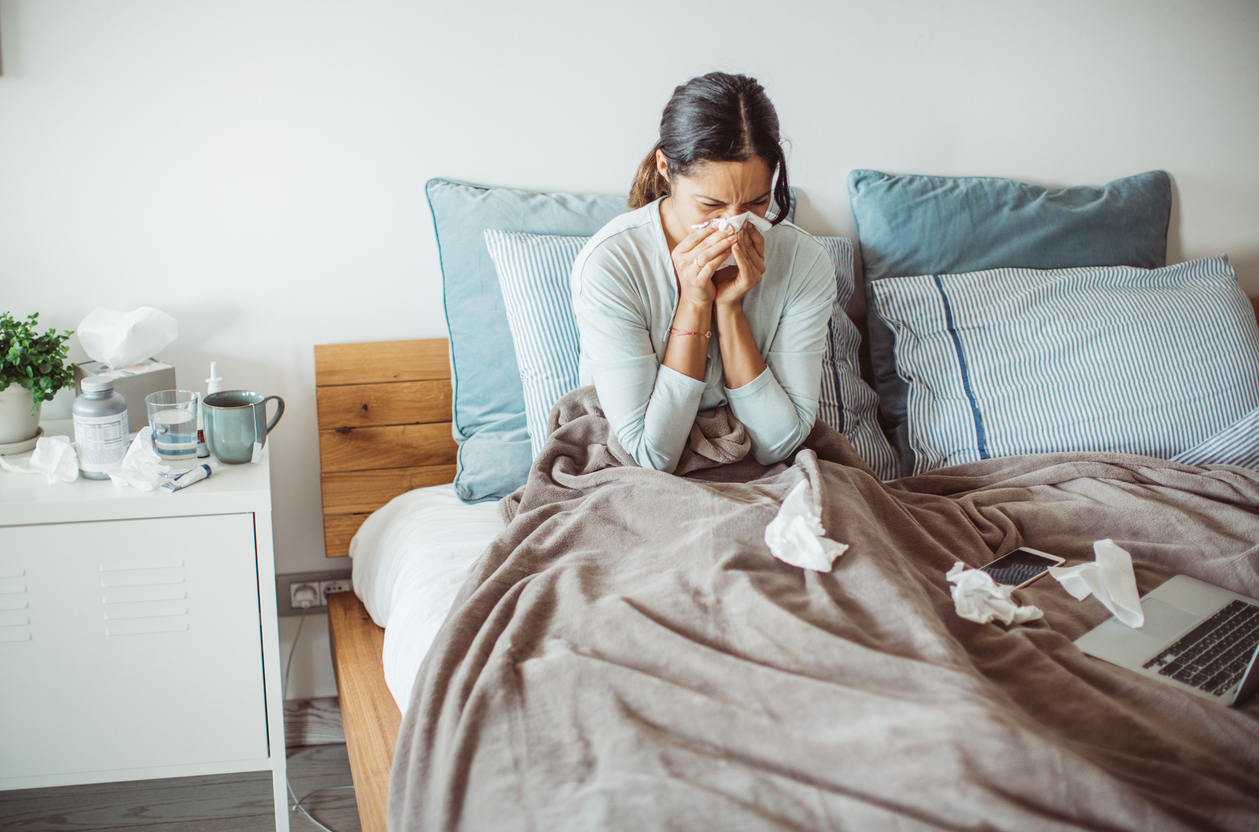 woman sick in bed with nasal congestion