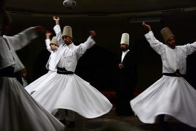 Members of the Islamic Mevlevi Order of Sufis during the Sama ceremony, a physically active meditation in remembrance of God. Photo by Schorle. CC by 3.0 via Wikimedia. Members of the Islamic Mevlevi Order of Sufis during the Sama ceremony, a physically active meditation in remembrance of God. Photo by Schorle. CC by 3.0 via Wikimedia.