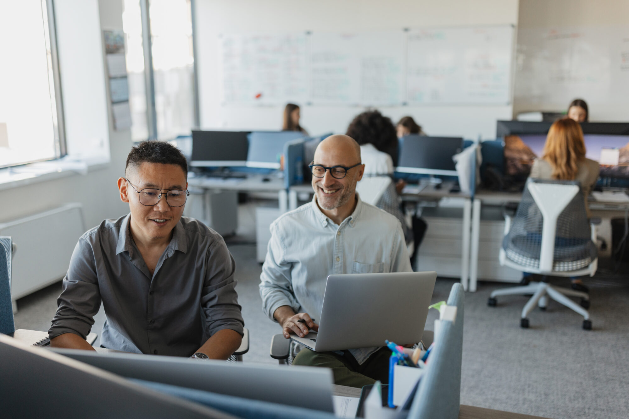 Two men collaborating over a laptop at work