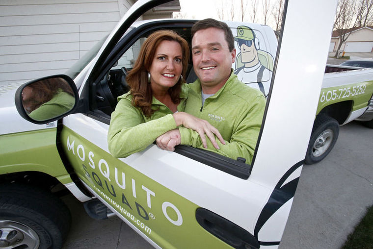 Greg Tople and his wife smile with their company vehicle.