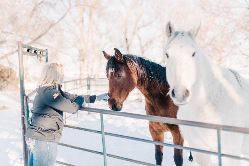 Maddy pets her two horses on her farm in South Dakota.