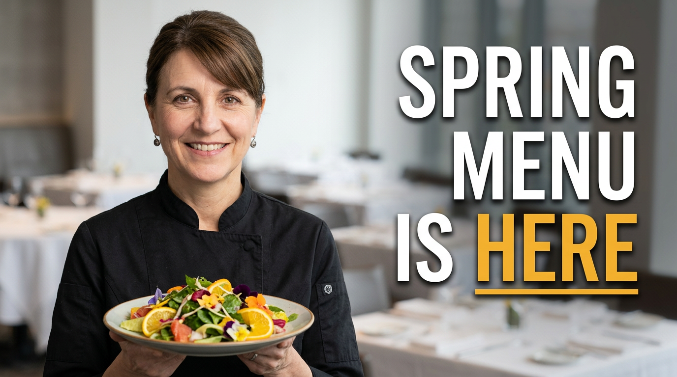 Female chef holding a colorful seasonal plate in a bright restaurant dining room