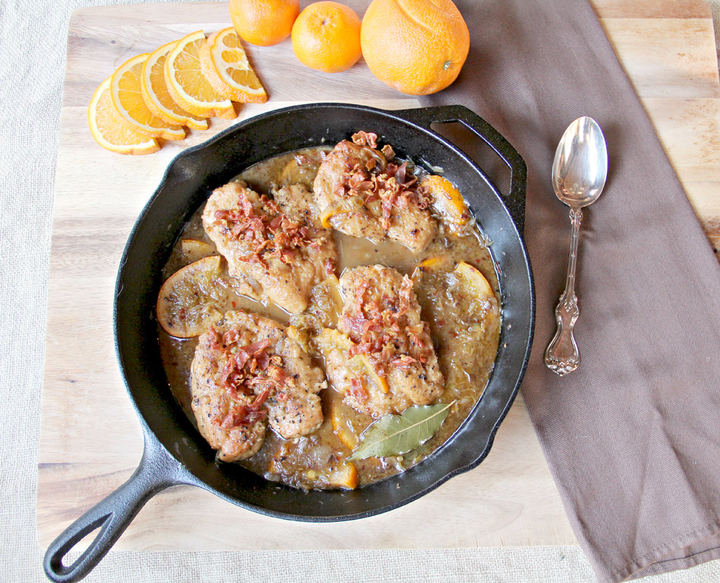 orange braised chicken with prosciutto in skillet